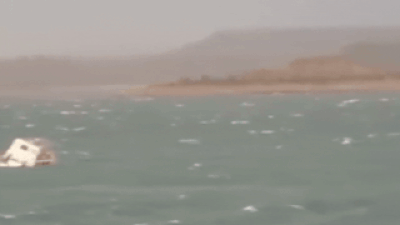 the footage shows the boat struggling against strong winds before losing balance and capsizing in turbulent waters